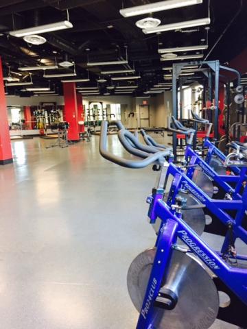 Interior of training gym. There is exercising equipment throughout the room.