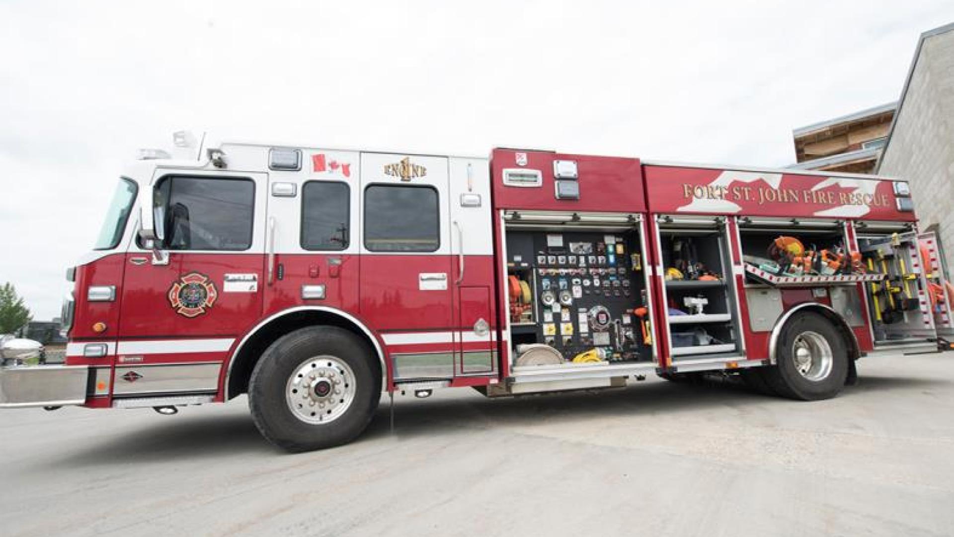 Red firetruck parked outside of fire station.