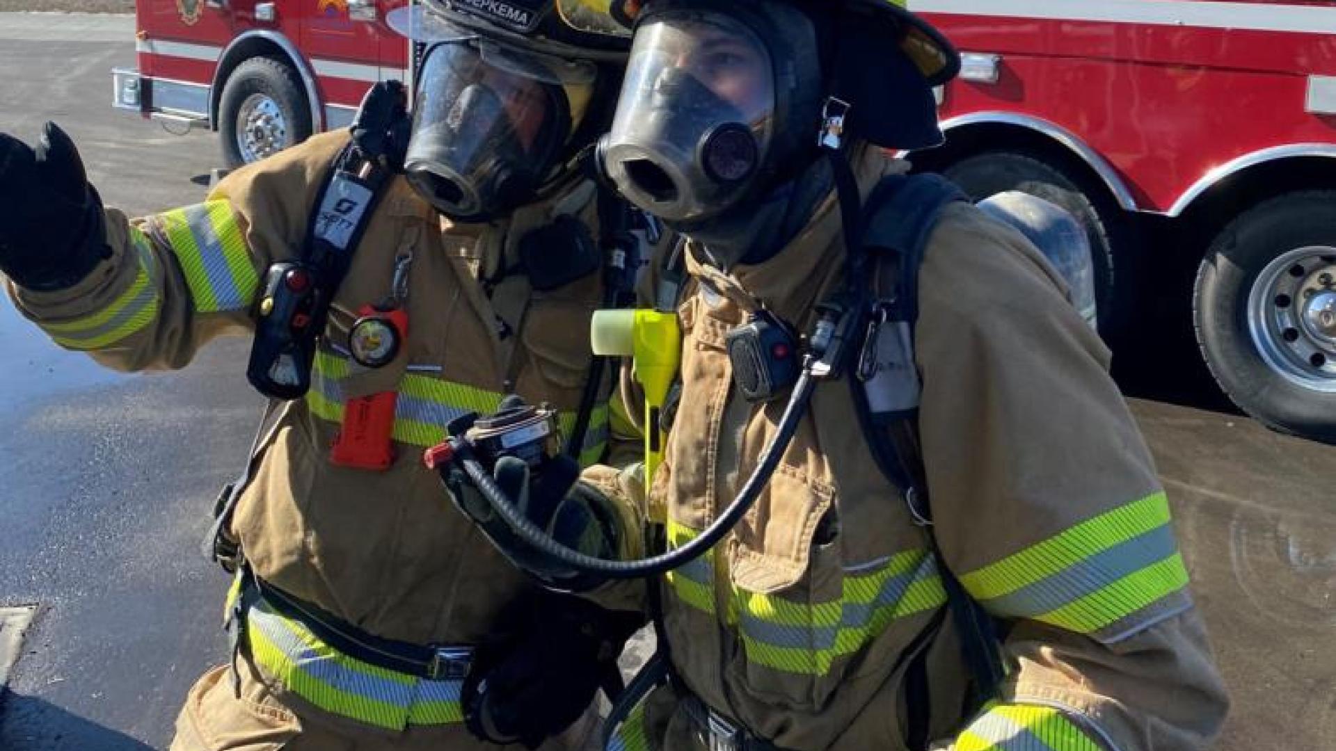 Two firefighters discuss their plan of attack.