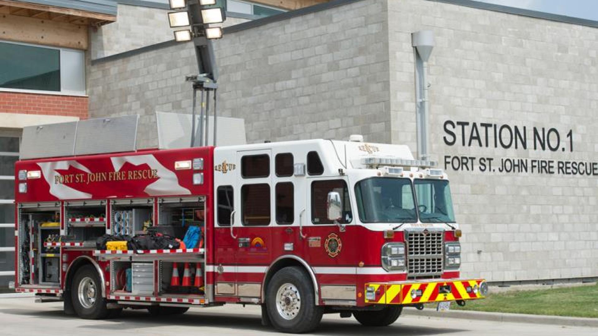 Red firetruck parked outside of fire station.