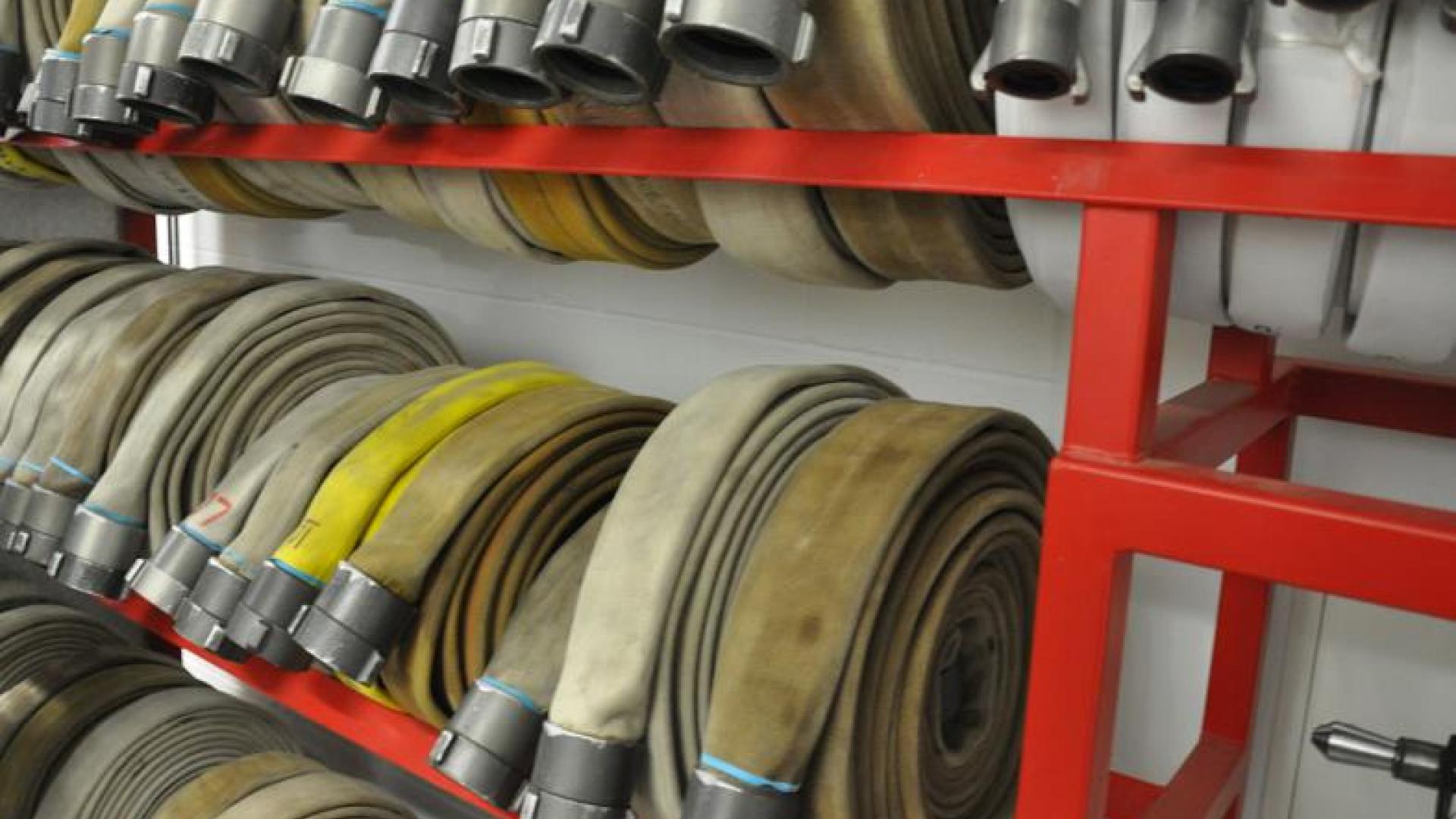 Rolled up firehoses on a rack.
