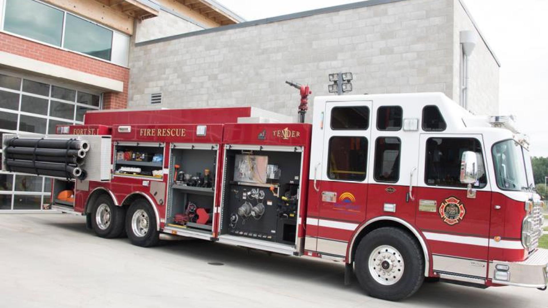 Firetruck parked in front of fire station.