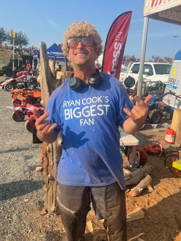 Kevin Lewis posing with a blue t-shirt that reads "Ryan Cook's biggest fan".