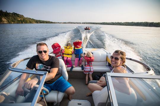 Family smiling while riding on speedboat.